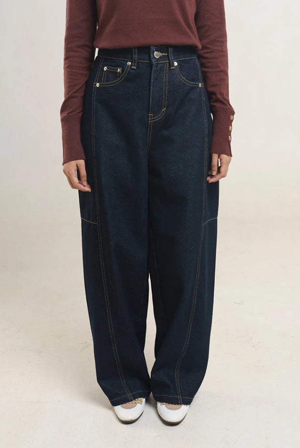 Person wearing dark blue denim pants by Jenna & Kaia and a maroon long-sleeve shirt on a light background
Seseorang yang mengenakan celana denim biru tua dari Jenna & Kaia dan kemeja lengan panjang berwarna merah marun di atas latar belakang terang