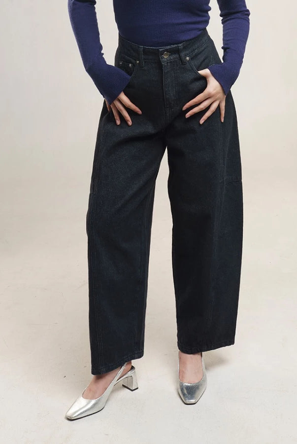 Person wearing black high-waisted denim pants by Jenna & Kaia and a dark top on a plain background
Seorang wanita mengenakan celana denim hitam berpinggang tinggi dari Jenna & Kaia serta atasan berwarna gelap di latar belakang polos