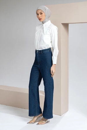 Woman wearing a white blouse and blue jeans with a hijab in a minimalistic setting.
Seorang wanita yang mengenakan blus putih dan celana denim biru serta hijab, dalam latar belakang yang minimalis.