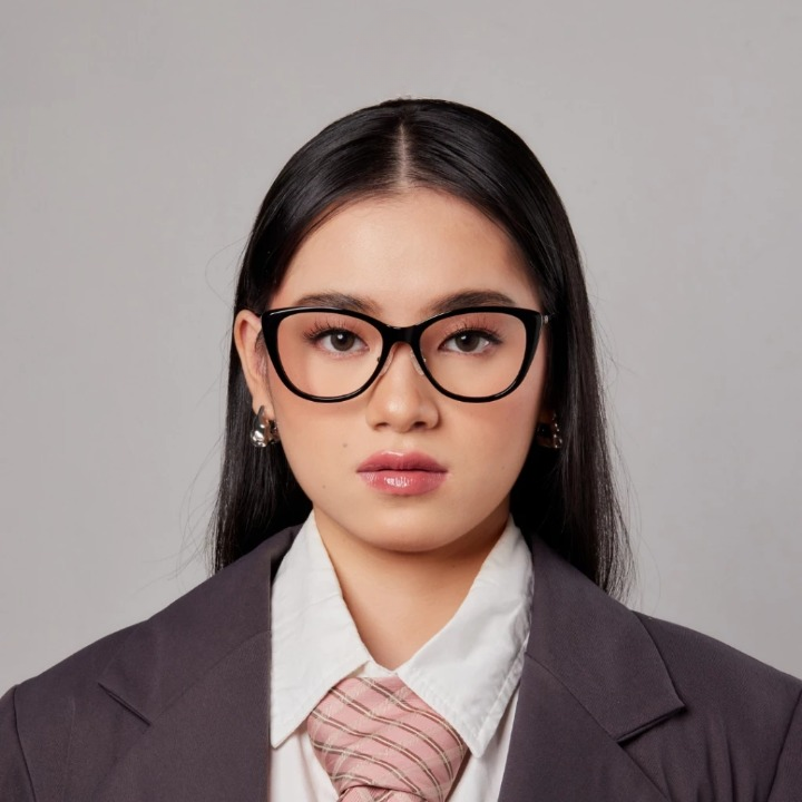 A person wearing HSF Nyra round eyeglasses with black frames.