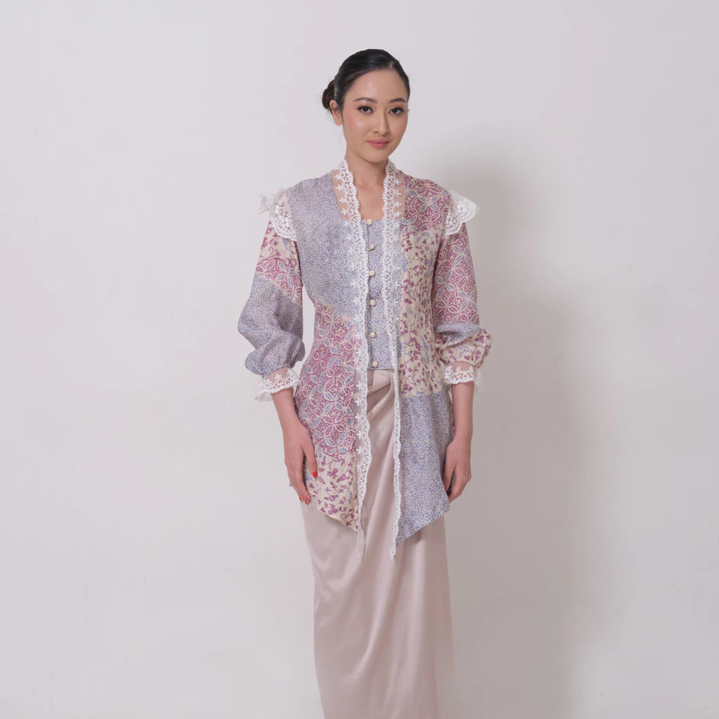 A woman wearing a traditional batik viscose kebaya by Kartinis Label with lace details and a keyhole front neckline in a misty print.