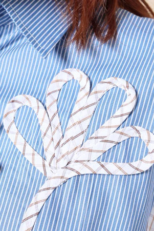 Blue and white striped shirt with a decorative bow design on the chest by Casa Elana.