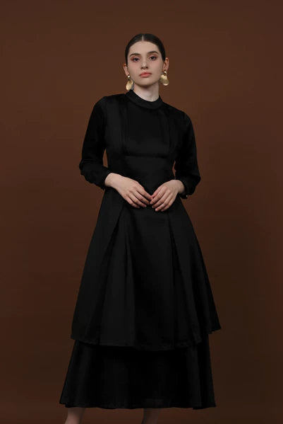 Seorang wanita memakai tunik berlengan panjang berwarna charcoal dari brand Kasa Heritage.