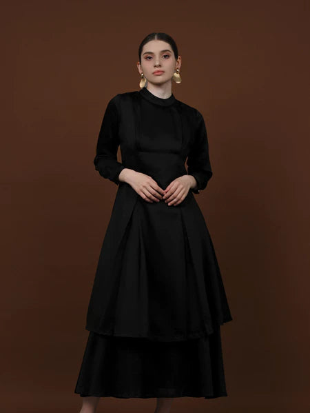 Seorang wanita memakai tunik berlengan panjang berwarna charcoal dari brand Kasa Heritage.