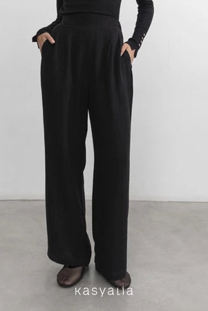 Black wide-leg pants worn by a person on a plain background with 'kasyalia' branding.