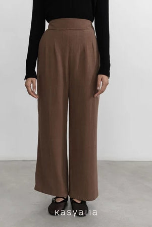 Brown wide-leg pants worn by a person on a plain background with 'kasyalia' branding.