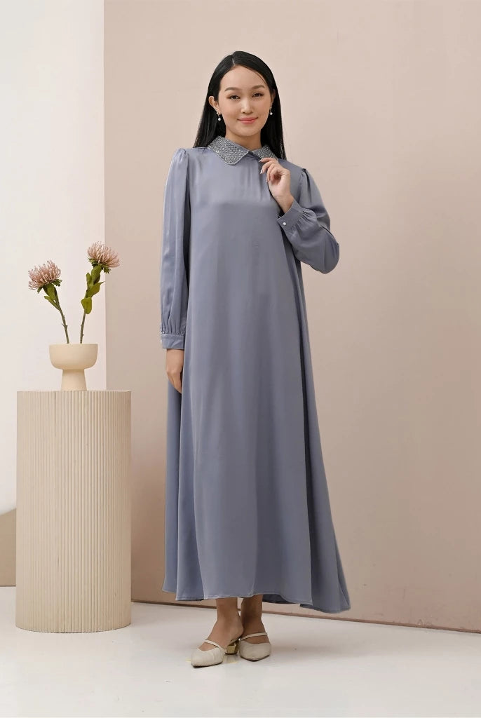 A woman wearing a blue dress with long sleeves by Kasa Heritage, featuring a mandarin collar with detail and a detachable belt.