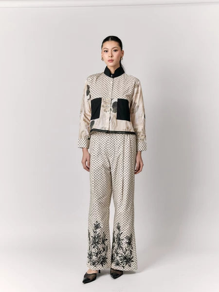 Woman wearing a stylish outfit with a patterned top and pants by Studio Tui on a white background