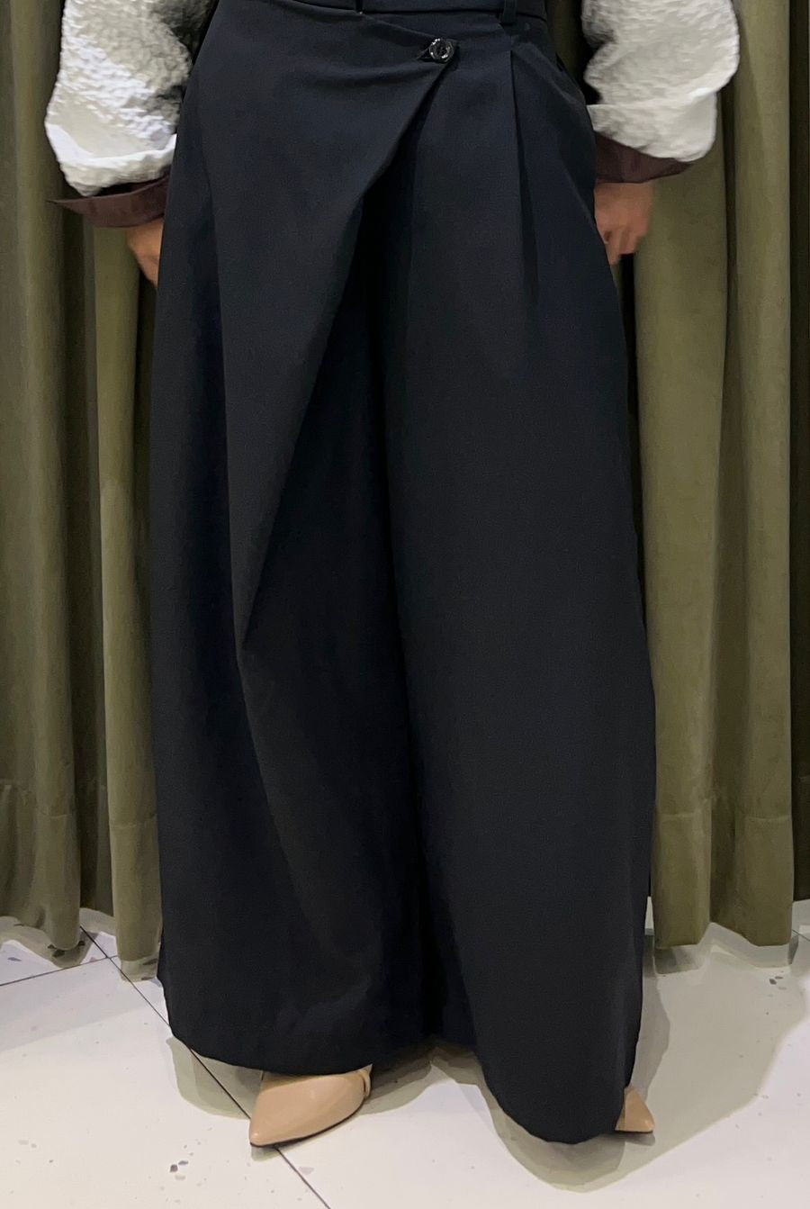 Person wearing a white top and black wide-leg Maima pants against a neutral background