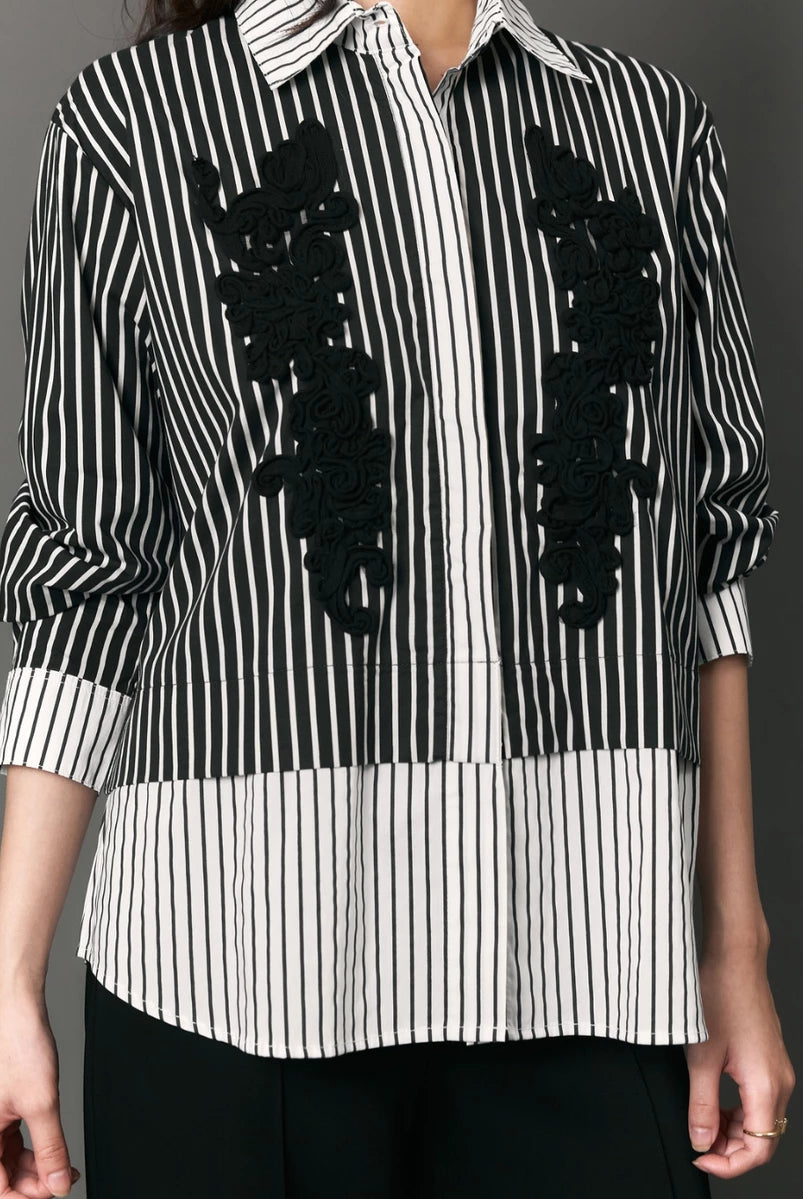Black and white striped shirt with black floral appliqués by Studio Tui on a gray background