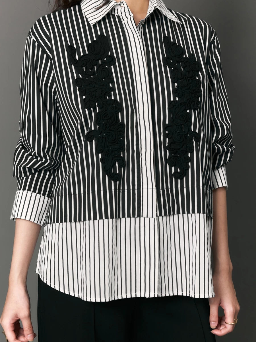 Black and white striped shirt with black floral appliqués by Studio Tui on a gray background