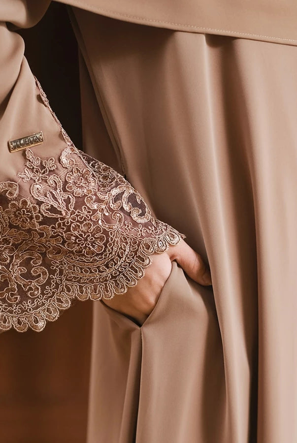 Close-up of a brown abaya with lace sleeve with intricate detailing by Tubita.