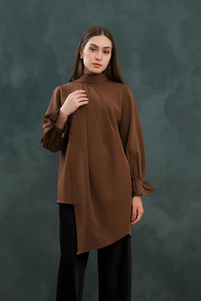Woman wearing a brown long-sleeve blouse by Kasa Heritage against a dark background