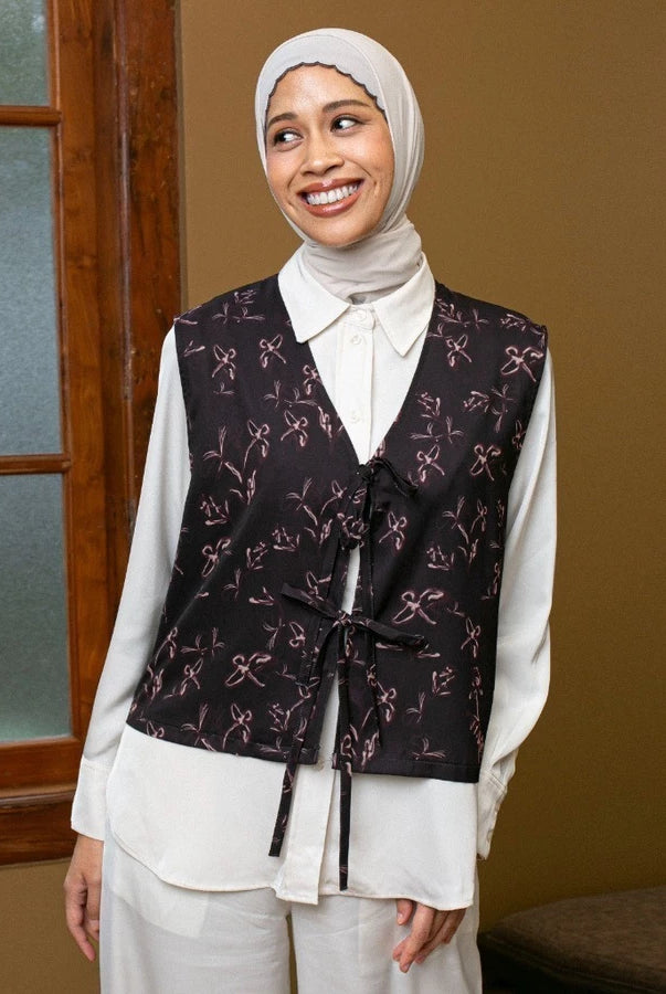 Woman wearing a patterned dark brown vest by Lozy Hijab over a white shirt in an indoor setting