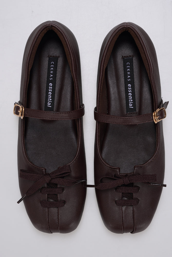 A pair of brown Mary Jane ballet flatshoes by Cekhas with matching ribbon bows and small gold-tone buckle details, displayed on a light gray background.