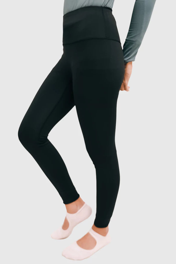 Person wearing black leggings by HIA on a light gray background