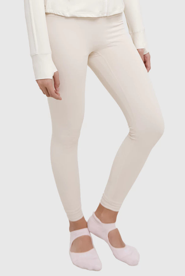 Person wearing cream leggings by HIA and pink socks on a white background
