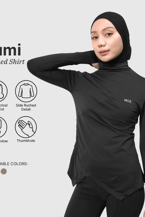 Woman wearing a black HIA Lumi ruched shirt with features highlighted on a light gray background.