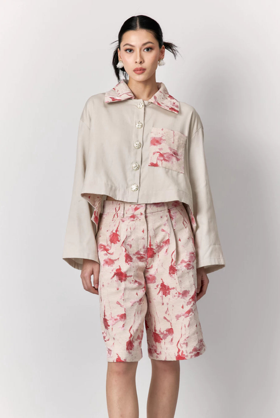 Model wearing a beige jacket with floral details by Studio Tui on a white background