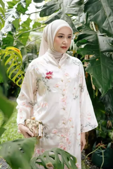 Woman in a pink floral tunic by Haidee Orlin standing among green plants
Seorang wanita mengenakan tunik bermotif bunga berwarna pink karya Haidee Orlin sedang berdiri di antara tanaman hijau