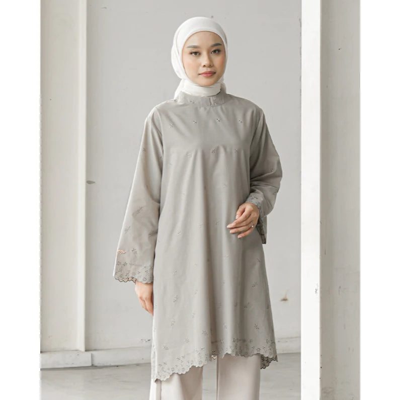 Woman wearing a light gray long-sleeve tunic by Mistyvori with lace details against a white background
Wanita mengenakan tunik lengan panjang berwarna abu-abu muda dari Mistyvori dengan detail renda di atas latar belakang putih.