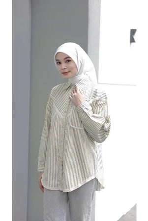 Woman wearing a yellow striped shirt by Abame and hijab against a plain background