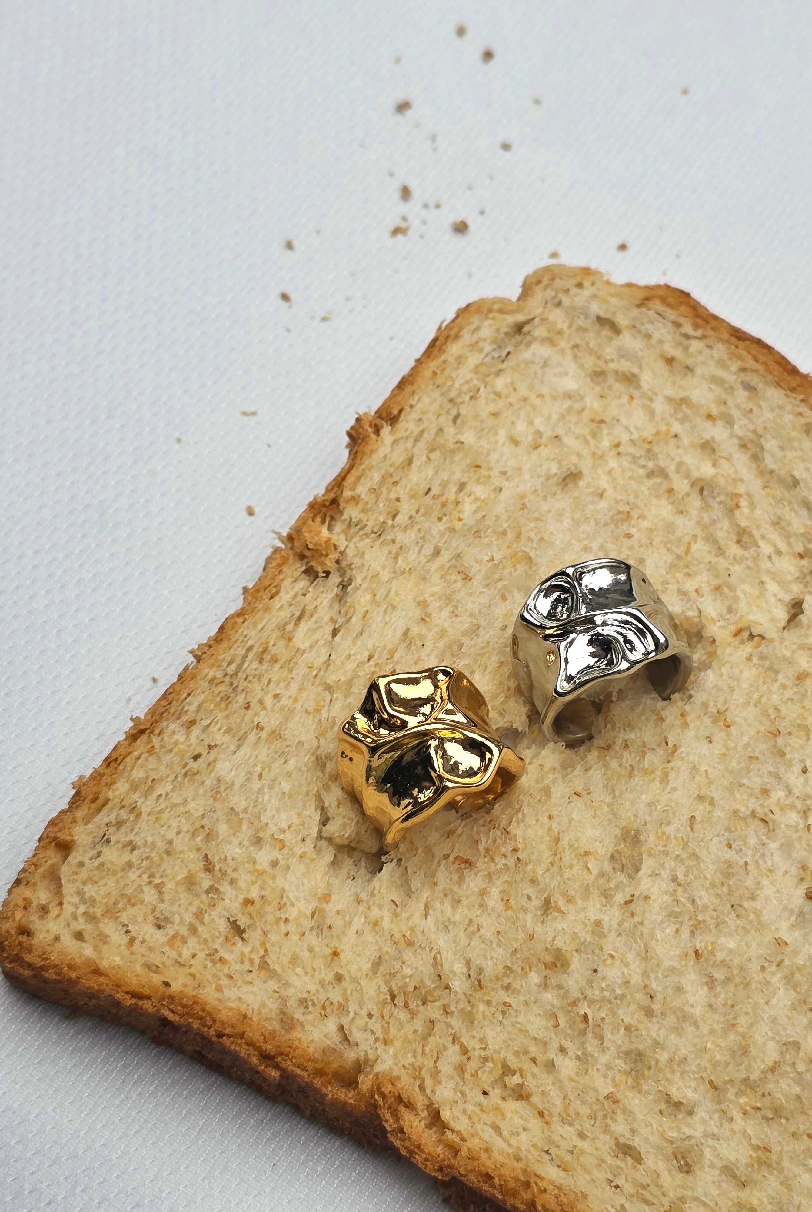Gold and silver rings by Darje on a slice of bread
