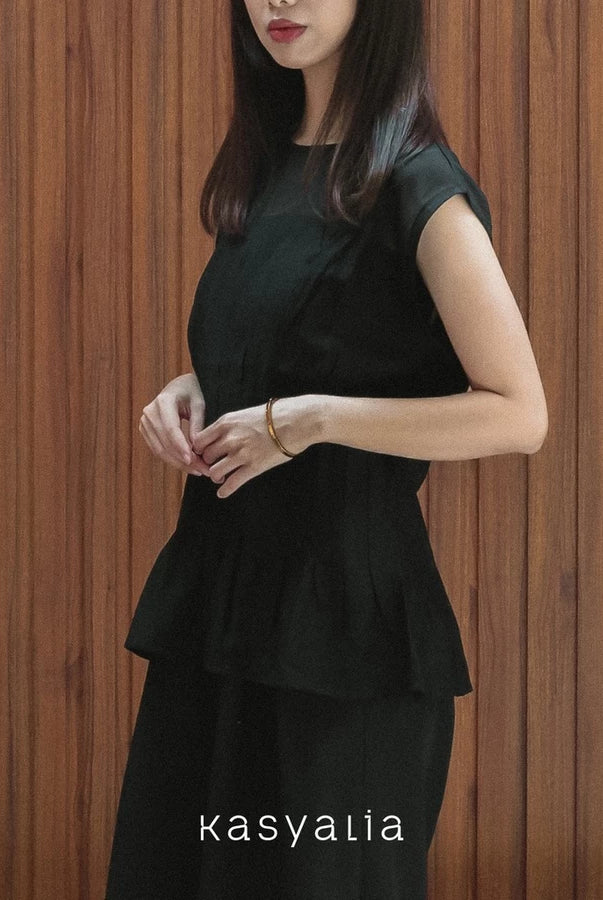Woman wearing a black blouse against a wooden background with 'kasyalia' branding.