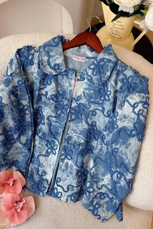 Sky blue floral-patterned jacket from Haidee Orlin on a chair with flowers around