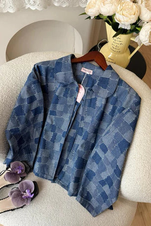 Blue checkered denim jacket from Haidee Orlin on a hanger with a blurred background