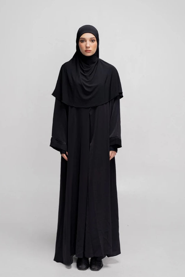 Person wearing a black abaya by Tubita on a white background