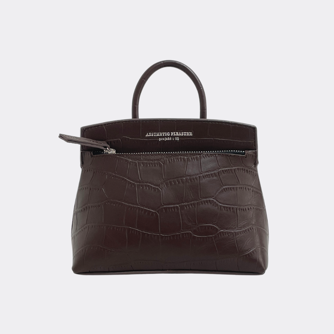 Brown crocodile textured mini-sized handbag with a visible brand name Aesthetic Pleasure on a light gray background
