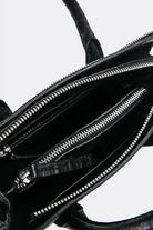 Close-up of a black leather mini handbag by Aesthetic Pleasure with zippers on a white background