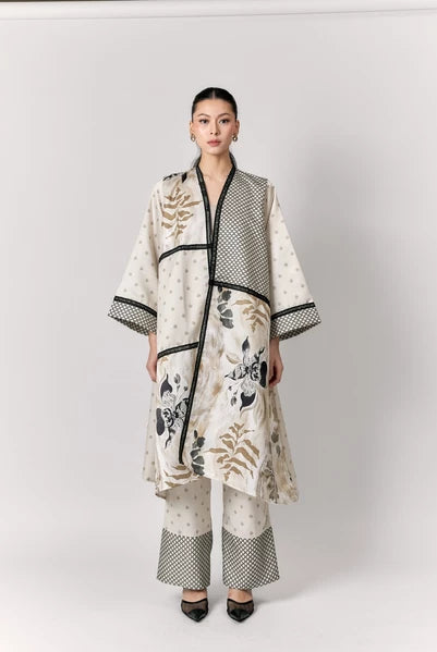 Woman wearing a stylish outer with a floral pattern by Studio Tui on a white background