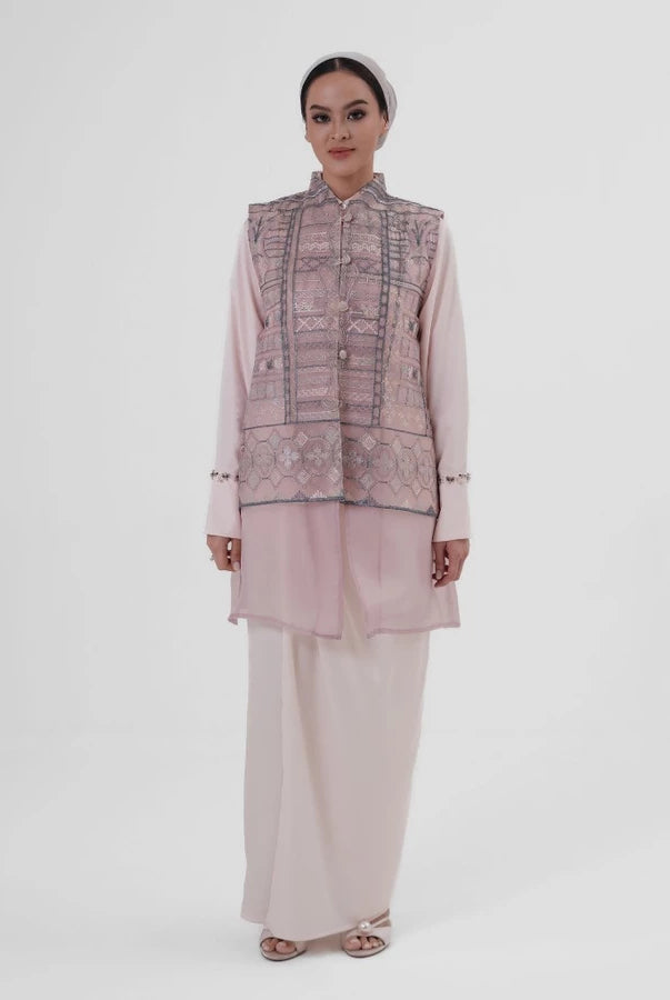 Woman wearing a pink tunic by Jenna & Kaia with long skirt on a white background