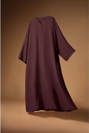 Burgundy Mecca Dhurma Abaya by Nehhat Modest on a brown background