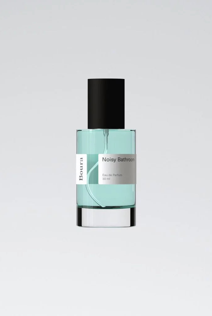 Perfume bottle with a black cap and light blue liquid from Boura on a gray background