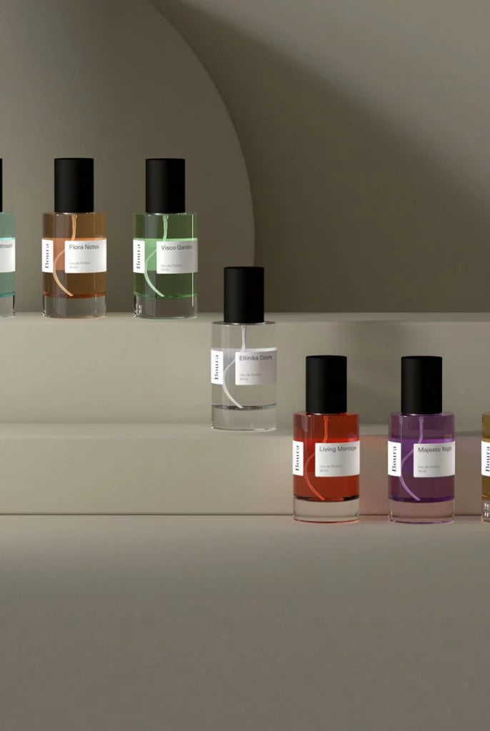 Row of perfume bottles with black caps from Boura on a neutral background