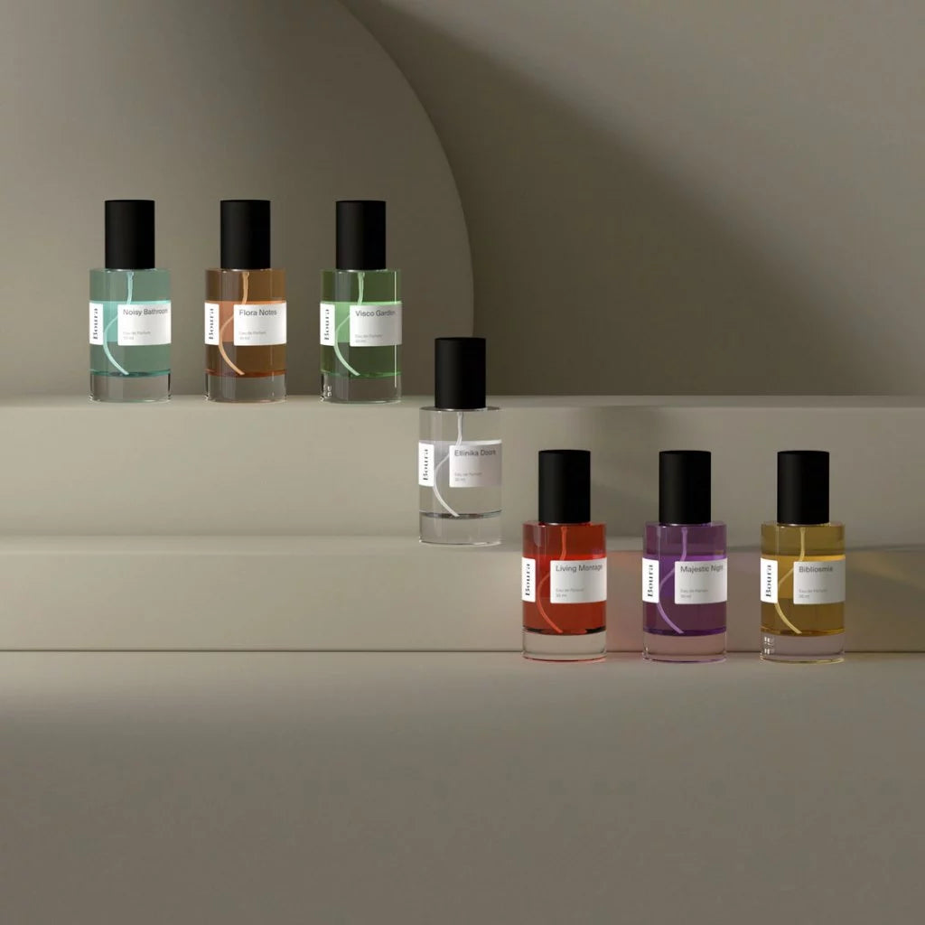 Row of perfume bottles with black caps from Boura on a neutral background