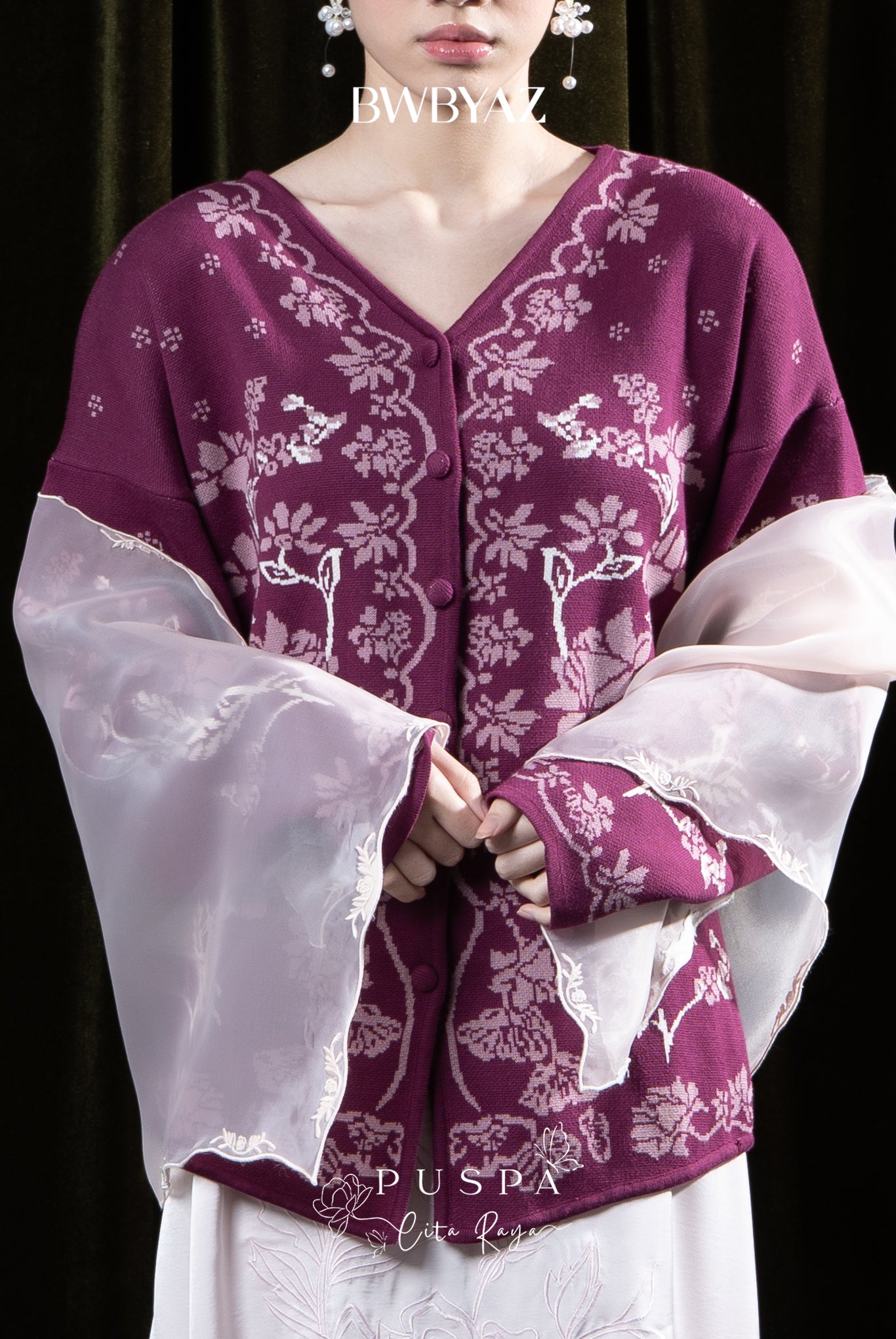 Person wearing a maroon floral cardigan by BWBYAZ against a dark background
