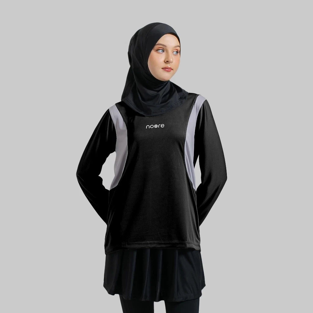 A woman wearing a black activewear top with the brand name 'noore' on the front, paired with a black headscarf.