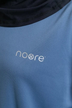 Blue activewear tops with 'noore' logo on a close-up of fabric texture