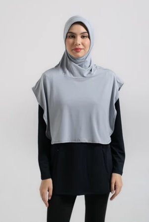 Woman wearing a light gray hijab sport by Noore and black outfit on a white background