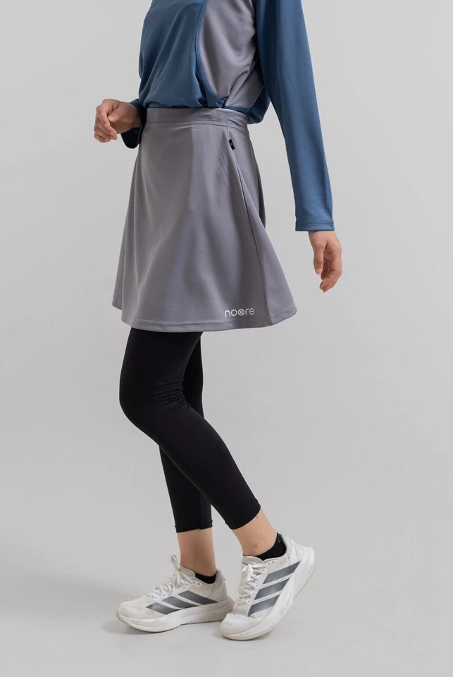 Person wearing a gray seraphina skirt pro from Noore on a light gray background