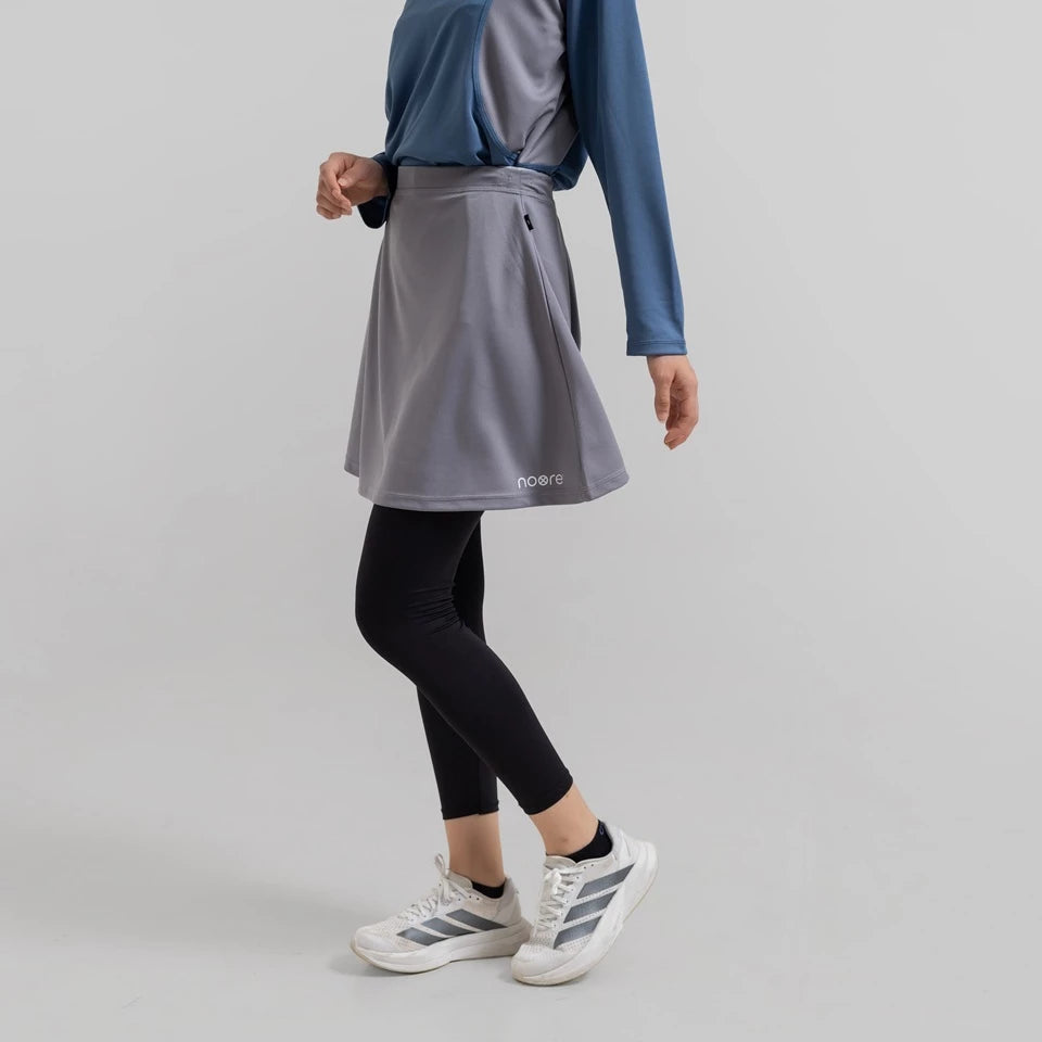 Person wearing a gray seraphina skirt pro from Noore on a light gray background