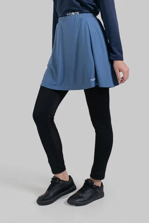 Person wearing a stone blue seraphina skirt pro from Noore on a gray background
