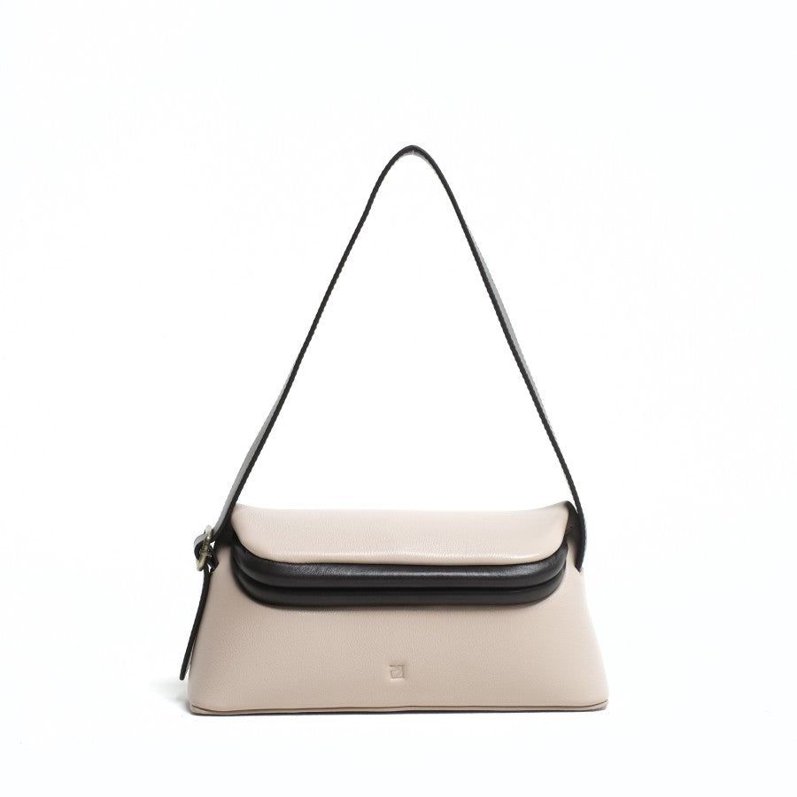 A taupe-colored shoulder bag with a flap closure and an adjustable long strap from purotti, displayed against a plain background.