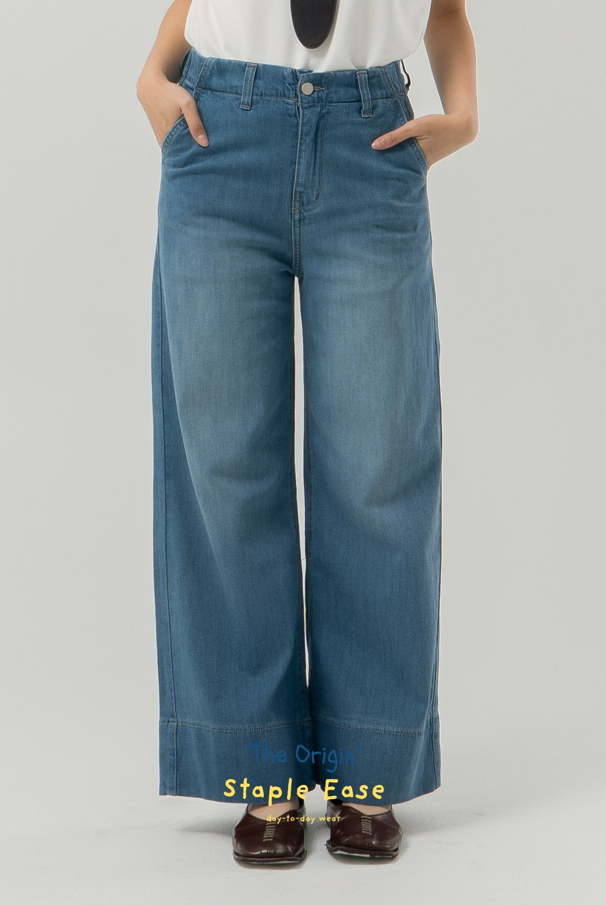 Blue wide-leg jeans from BWBYAZ worn by a person on a gray background.
