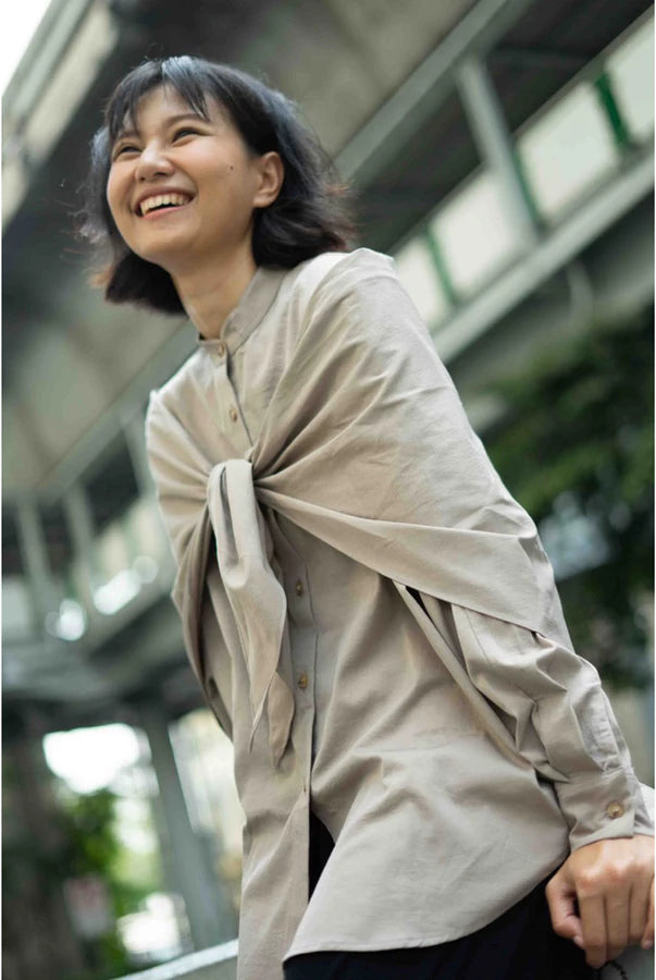 Woman wearing a beige shirt by Yestoday with a blurred background