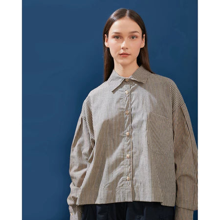 Person wearing a brown striped shirt by Yestoday against a blue background